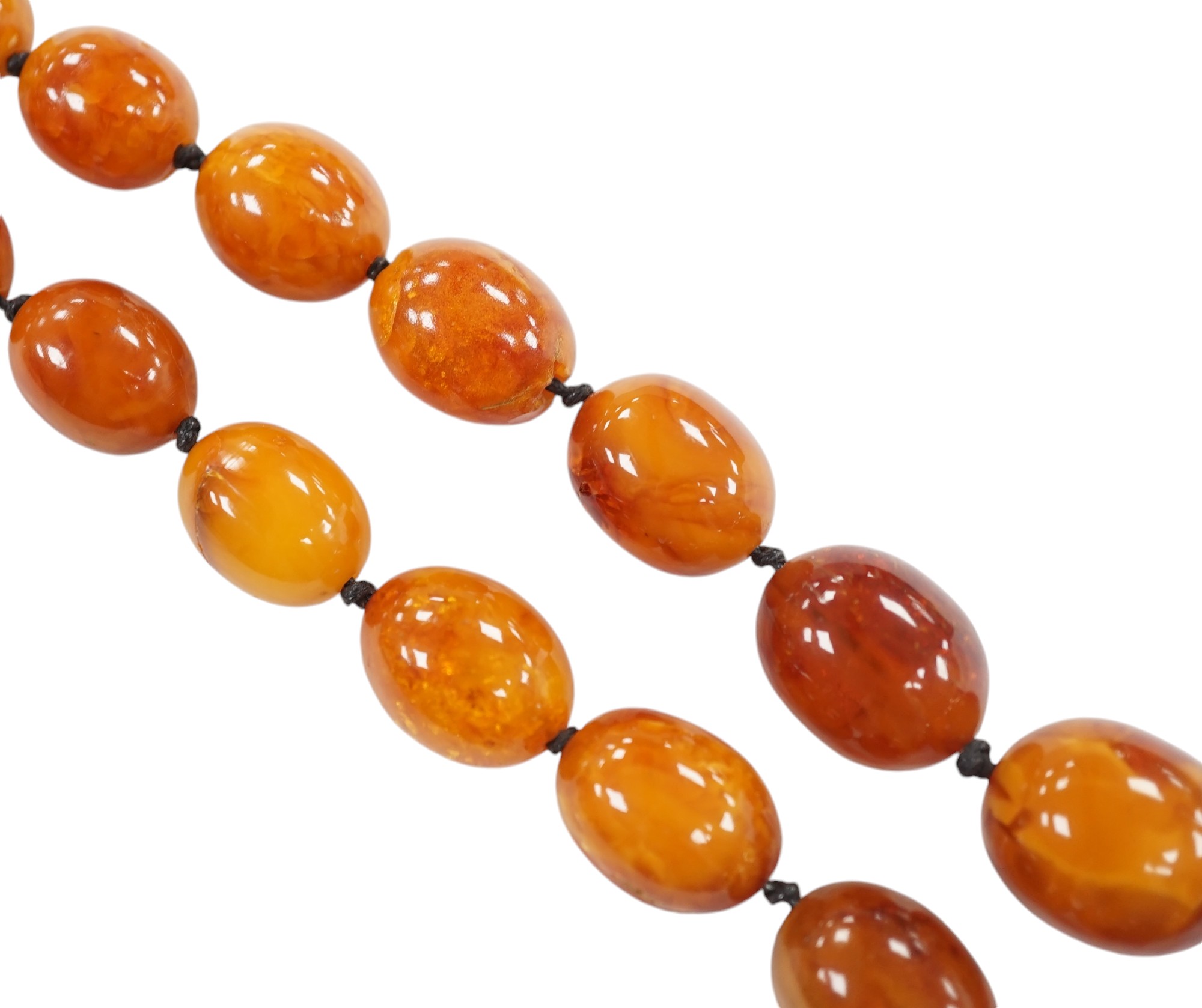 A single strand graduated oval amber bead necklace, 76cm, gross weight 107 grams. Condition - poor